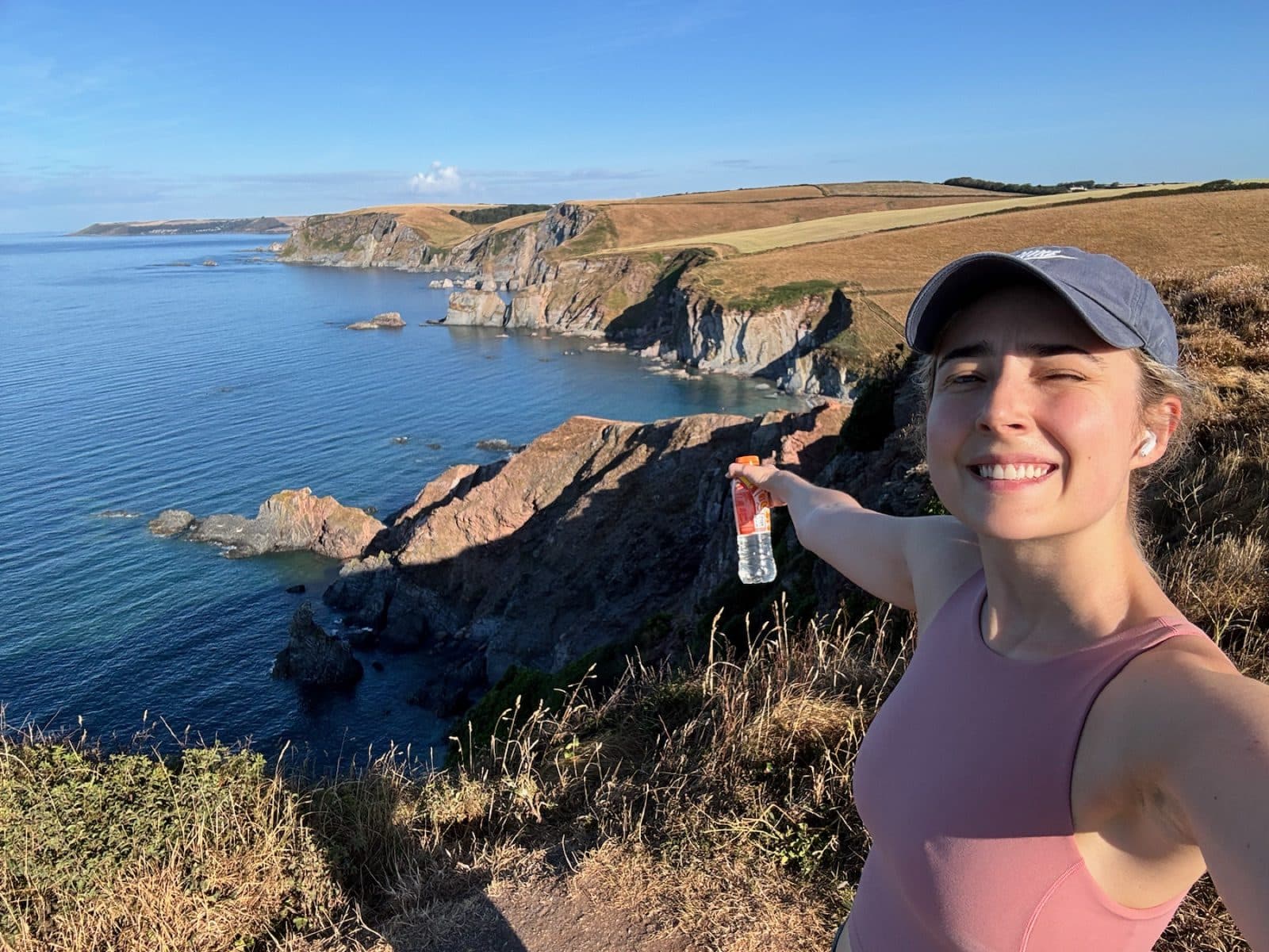 Annie taking a selfie while running beside a clifftop coast